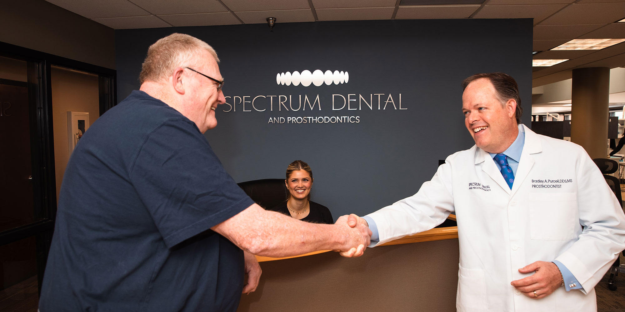 patient and doctor shaking hands within the dental practice